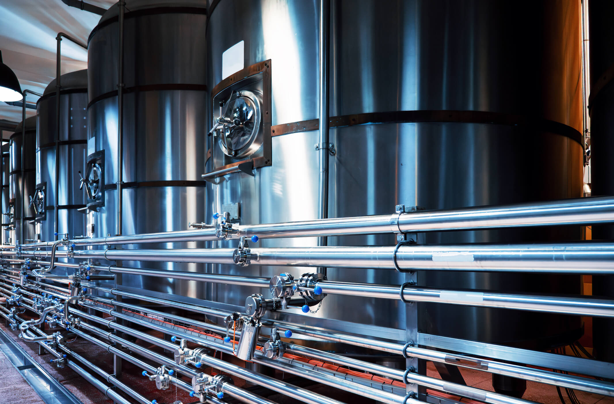 Modern brewery steel tanks and intricate piping, precision and quality in craft beer production.